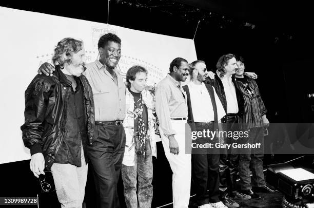 Portrait of, from left, musicians Levon Helm , Clarence Clemons , Nils Lofgren, Billy Preston , Ringo Starr, Joe Walsh, and Rick Danko during a press...