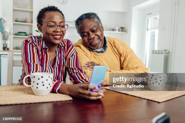 feliz pareja afroamericana senior navegando por la red en un teléfono inteligente - old phone fotografías e imágenes de stock