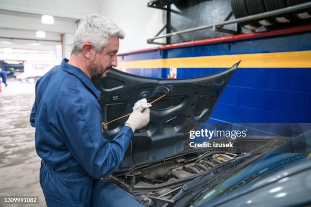 car mechanic at work - car lubricants stock pictures, royalty-free photos & images