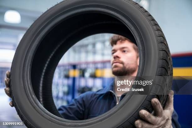 car mechanic checking tire - pneu imagens e fotografias de stock