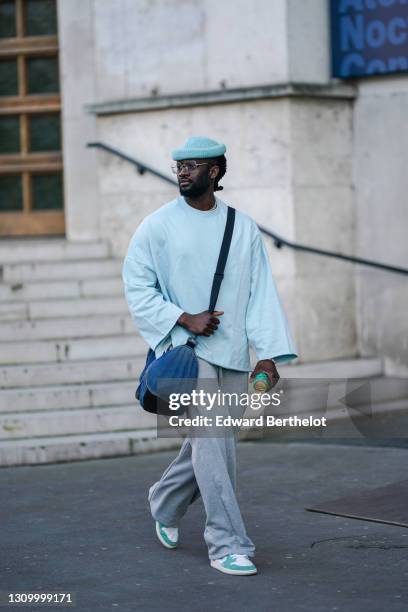 Cali Chiki wears glasses from Ray-Ban, a pale blue wool beanie hat from HM, a pale blue oversized pullover from Asos, gray jogger sport pants from...