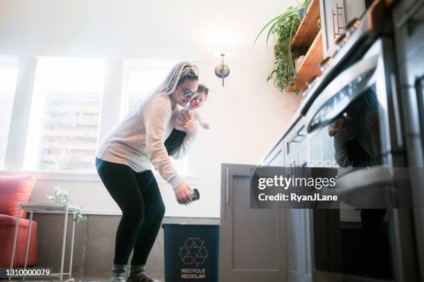 mother recycling empty containers with son - mixed recycling bin stock pictures, royalty-free photos & images