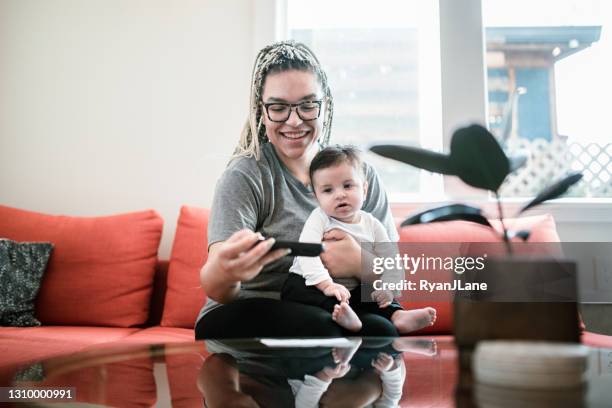 woman doing remote deposit capture with infant son - cheque deposit stock pictures, royalty-free photos & images