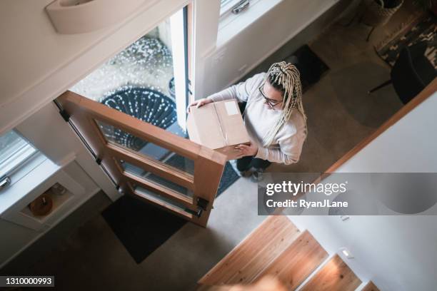 woman bringing package delivery into her home - returning product stock pictures, royalty-free photos & images