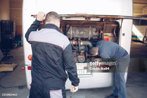 male mechanic and assistant working on a bus motor - truck repair stock pictures, royalty-free photos & images
