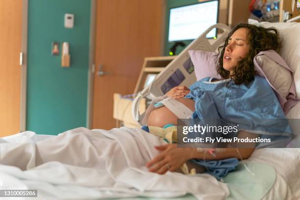 ethnic woman in hospital bed breathing through contraction - breathing new life stock pictures, royalty-free photos & images