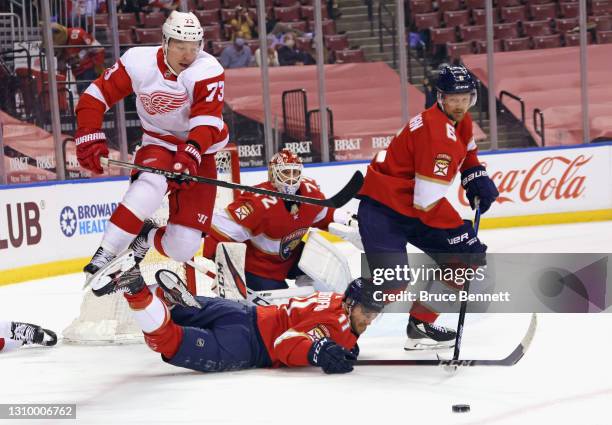 Adam Erne of the Detroit Red Wings and Jonathan Huberdeau of the Florida Panthers battle for the puck during the first period at the BB&T Center on...