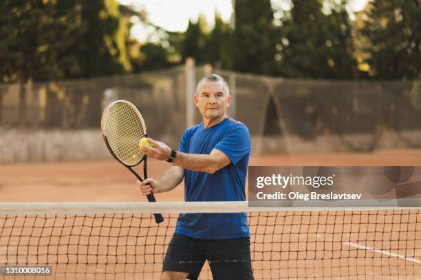 serious and concentrated on game tennis player with racquet before pitch. active senior man - amateur tennis man stock pictures, royalty-free photos & images