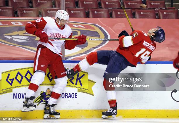 Mason Marchment of the Florida Panthers is hit by Danny DeKeyser of the Detroit Red Wings during the second period at the BB&T Center on March 30,...