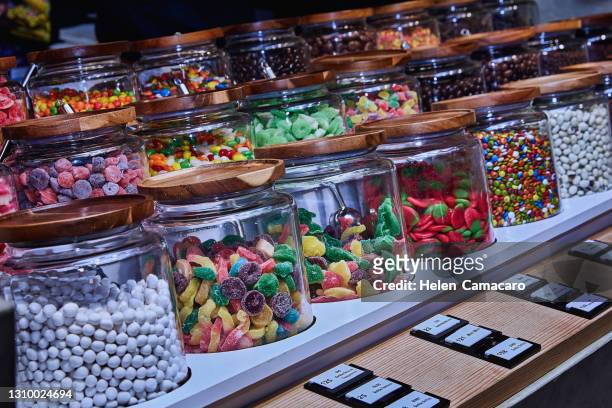 assorted variety of colorful candy in glass container - harde snoep stockfoto's en -beelden