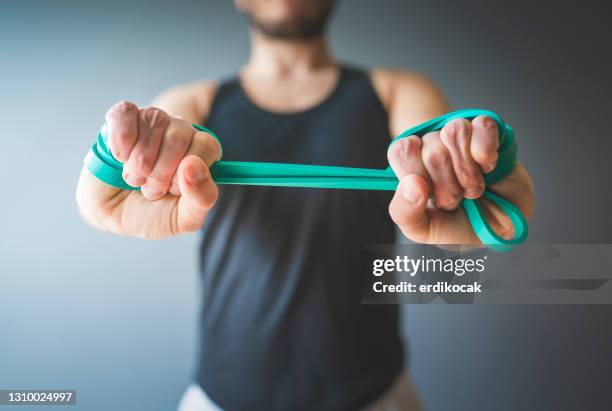 young man exercising at home - stretching home stock pictures, royalty-free photos & images