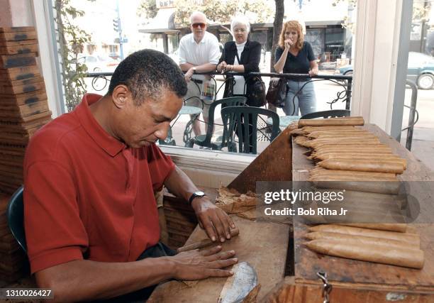 Tourists visiting GasLamp District in San Diego watch cigar maker Julio Ramirez hand-roll a Double Corona Torpedo cigar at the Gran Havana Cigar...