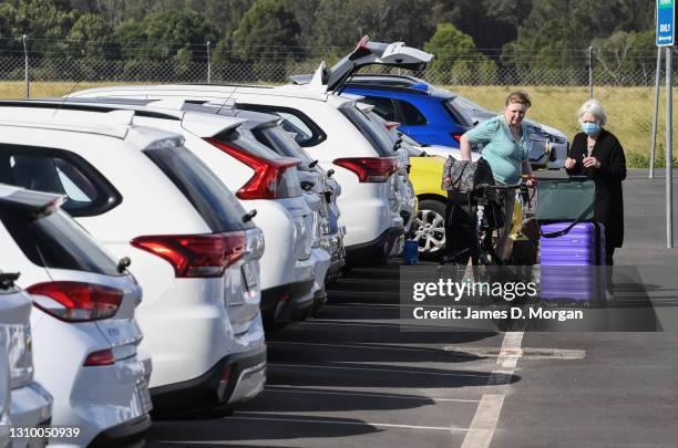 Two women, one wearing a face mask, load their luggage into a hire car at the airport on March 31, 2021 in Ballina, Australia. The NSW Government has...