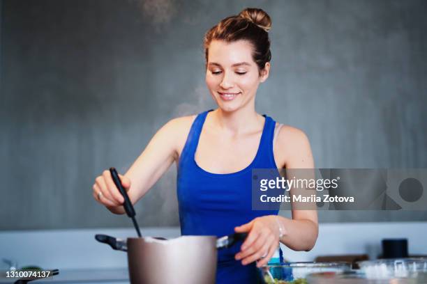 beautiful skinny girl cooks homemade food in the kitchen. female chef - utensile di portata foto e immagini stock