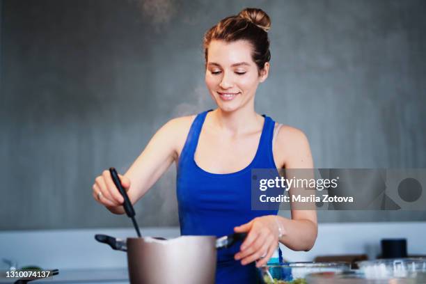 beautiful skinny girl cooks homemade food in the kitchen. female chef - utensílio de servir imagens e fotografias de stock