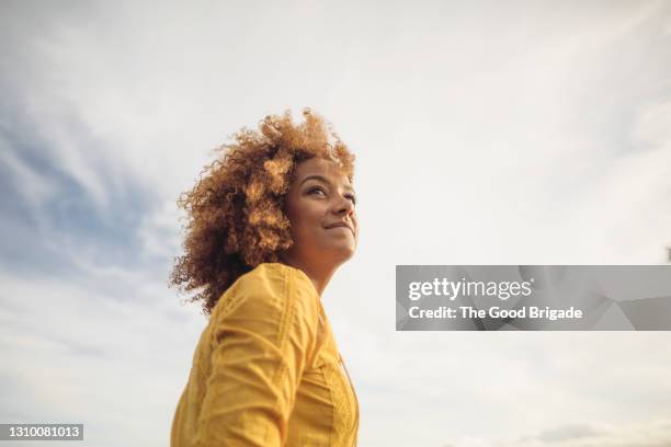 low angle portrait of beautiful woman against sky - vista de ángulo bajo fotografías e imágenes de stock