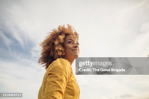 Low angle portrait of beautiful woman against sky Low angle portrait of beautiful woman against sky