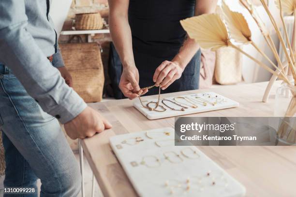 midsection of male entrepreneurs with bracelets standing by customer in design studio - jewellery shopping stock pictures, royalty-free photos & images