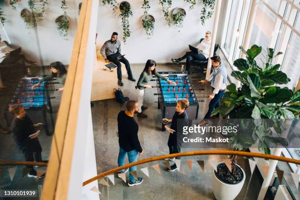 high angle view of business people taking break in office after meeting - coworking office stock-fotos und bilder