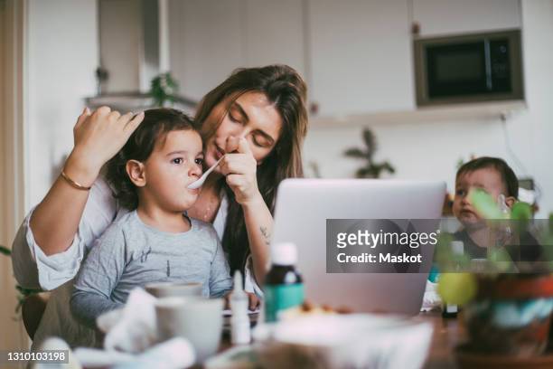 mother feeding son at home - stockholm syndrome stock pictures, royalty-free photos & images