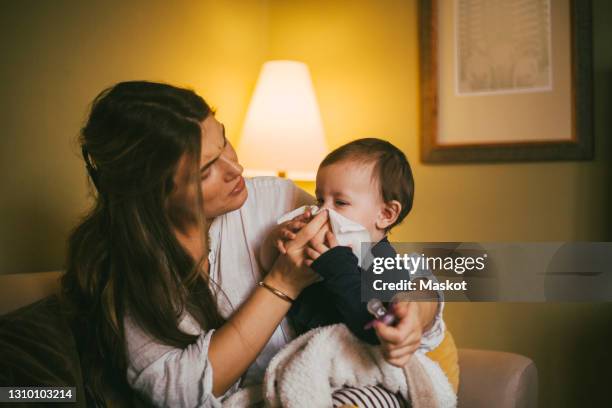 mother blowing nose of baby girl at home - sick woman blowing nose stock pictures, royalty-free photos & images