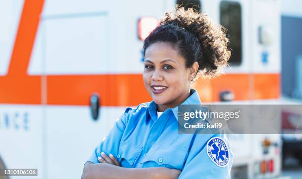 female paramedic in front of ambulance - paramedic stock pictures, royalty-free photos & images
