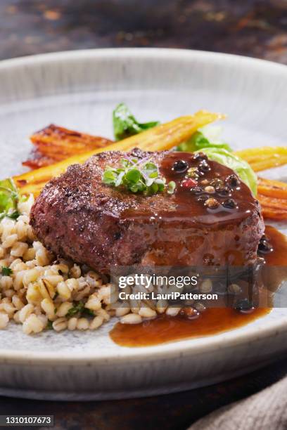 seared bison fillet steak with creamy mushroom herb barley - bison meat stock pictures, royalty-free photos & images