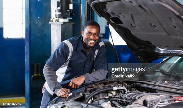african-american auto mechanic inspecting car engine - man working on car engine stock pictures, royalty-free photos & images