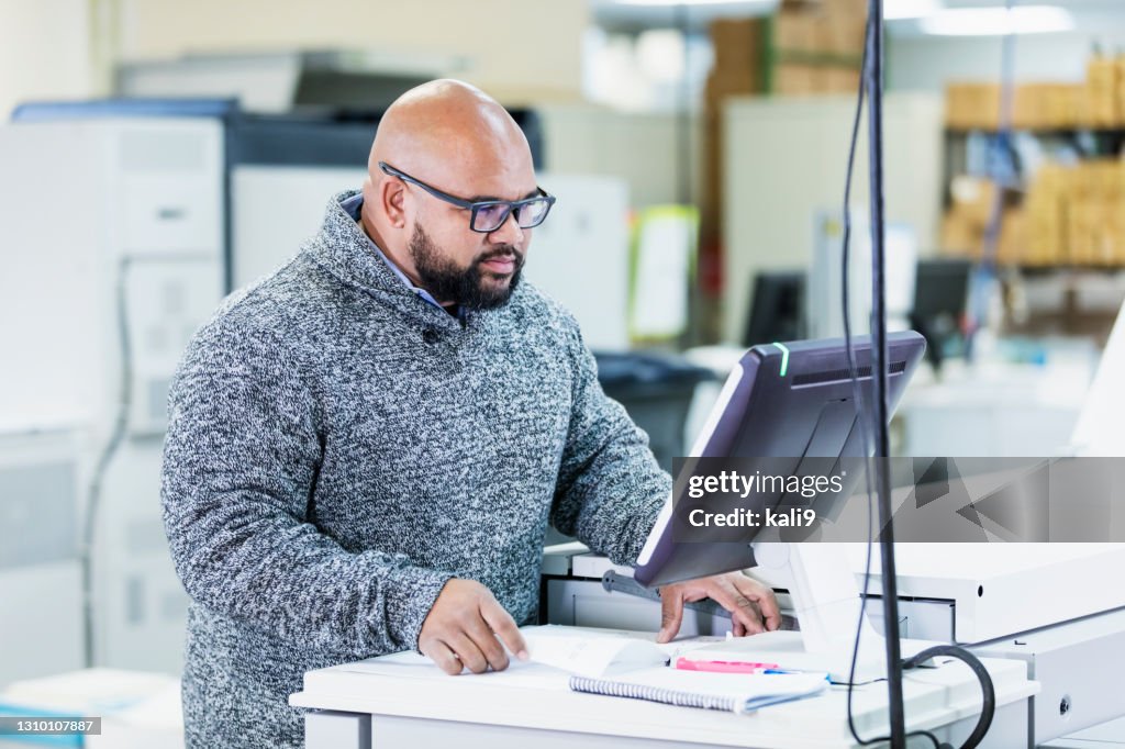 混血兒在印刷廠工作,在電腦上