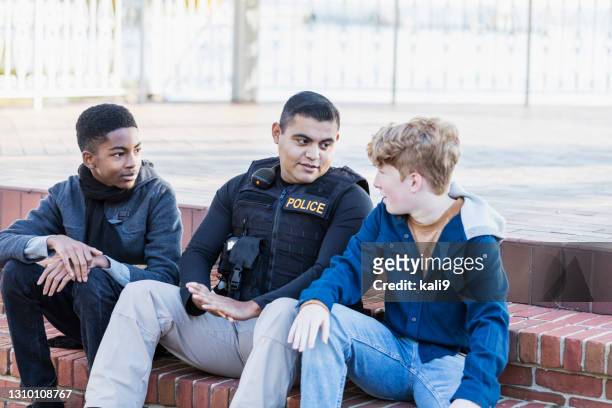 polizist in gemeinschaft, sitzend mit zwei jugendlichen - american influence stock-fotos und bilder