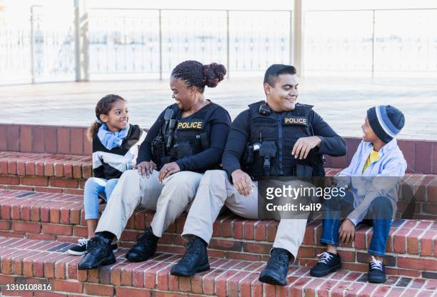 two police officers in community, sitting with children - police stock pictures, royalty-free photos & images