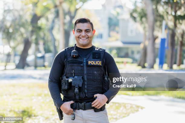 hispanic police officer on foot patrol - police officer smiling stock pictures, royalty-free photos & images