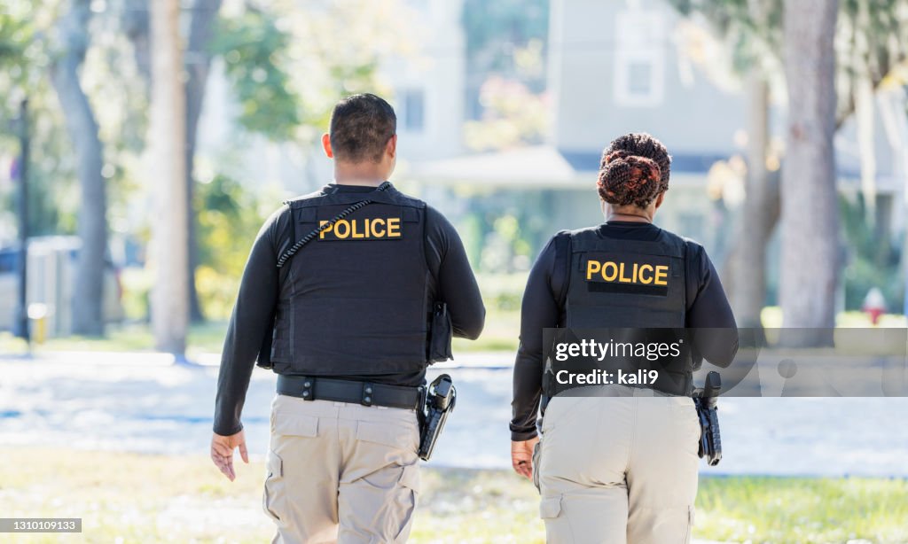 Dois policiais andando na comunidade