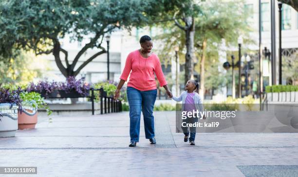アフリカ系アメリカ人の母と娘が都市公園を歩く - african american couple walking park ストックフォトと画像