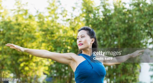 asian woman doing yoga, in warrior pose - beautiful filipino women stock pictures, royalty-free photos & images