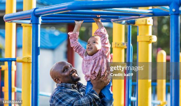 father and daughter with disability at playground - monkey bars stock pictures, royalty-free photos & images