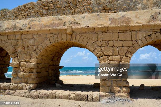 dichte omhooggaand van roman aquaduct op het strand caesarea in israël - sandstone wall stockfoto's en -beelden