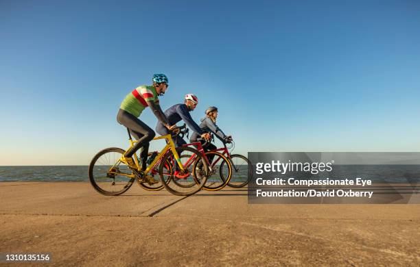 cyclists on path by sea - kent coastline stock pictures, royalty-free photos & images