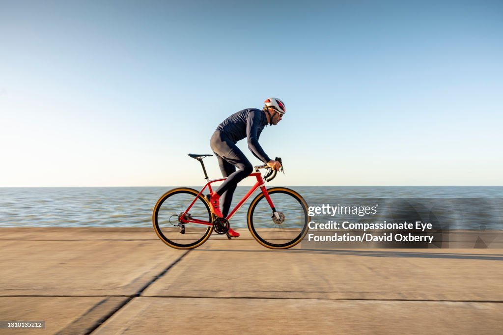 Cyclist on path by sea