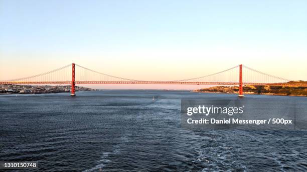 view of suspension bridge over sea,lisbon,portugal - provincie lissabon stockfoto's en -beelden