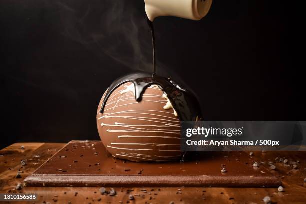 close-up of christmas decoration on table against black background - liquid chocolate stock pictures, royalty-free photos & images