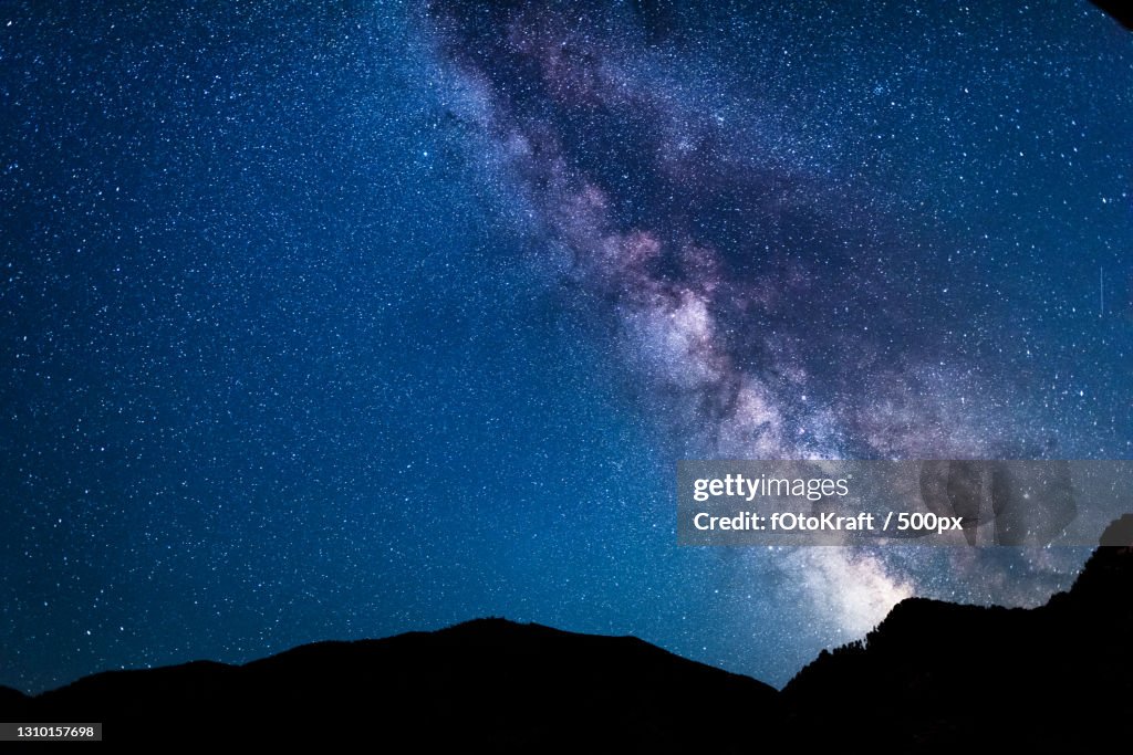 Low angle view of silhouette of mountain against star field at night,Austria