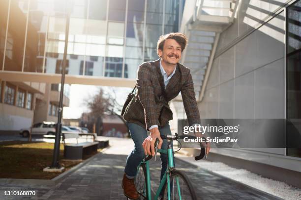 junger moderner geschäftsmann auf dem fahrrad - business fahrrad stock-fotos und bilder