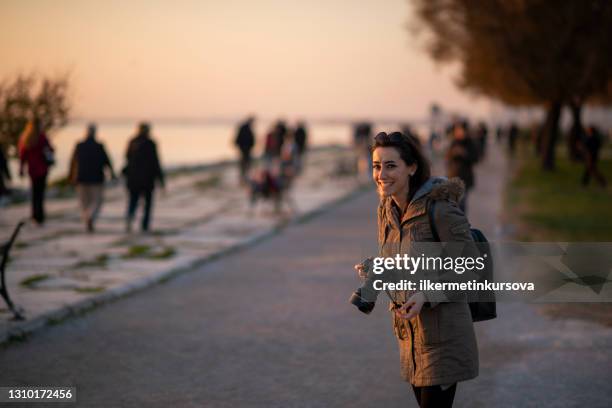 a young woman smiling with her camera - photojournalist stock pictures, royalty-free photos & images