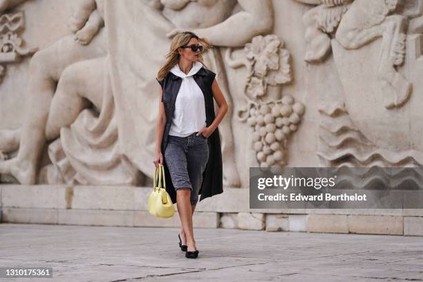 Natalia Verza @mascarada.paris wears sunglasses, a white hoodie sweater from Ferragamo, a black long leather sleeveless coat / dress from Ferragamo,...