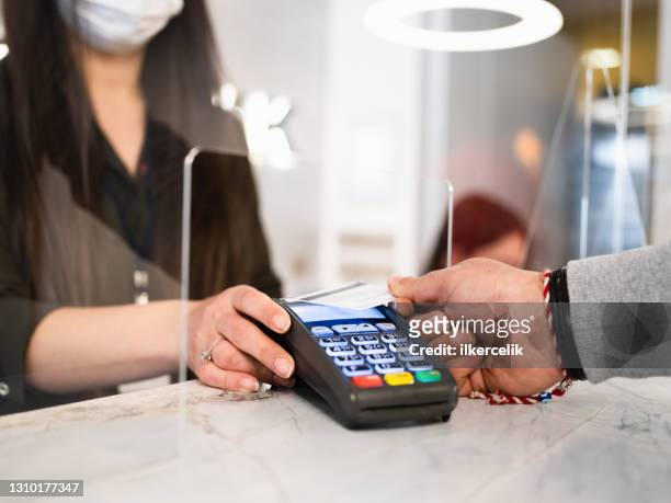 close up view of male hand making contactless payment using credit card - bank office clerks stock pictures, royalty-free photos & images
