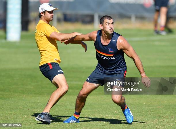 Taylor Walker of the Crows held by a trainer in a marking drill during the Adelaide Crows AFL training session at West Lakes on April 01, 2021 in...