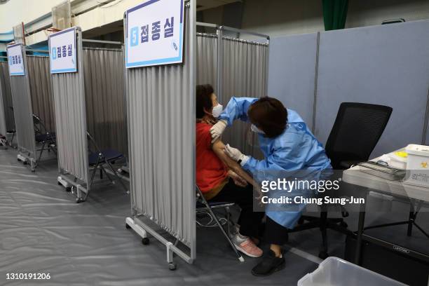 South Korean elderly woman receives the first dose of the Pfizer-BioNTech Covid-19 coronavirus vaccine at a vaccination centre on April 01, 2021 in...
