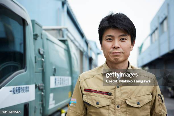 portrait of a garbage truck driver next to the car he is driving - 連身工作服 個照片及圖片檔