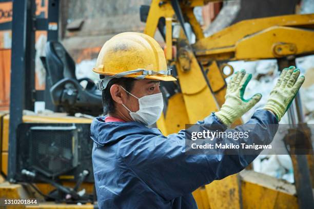 man working at an industrial waste treatment facility - japan covid stock pictures, royalty-free photos & images